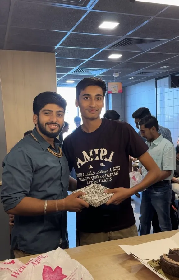 Ronak Sir handing a gift to an RD Classes student who scored 90+